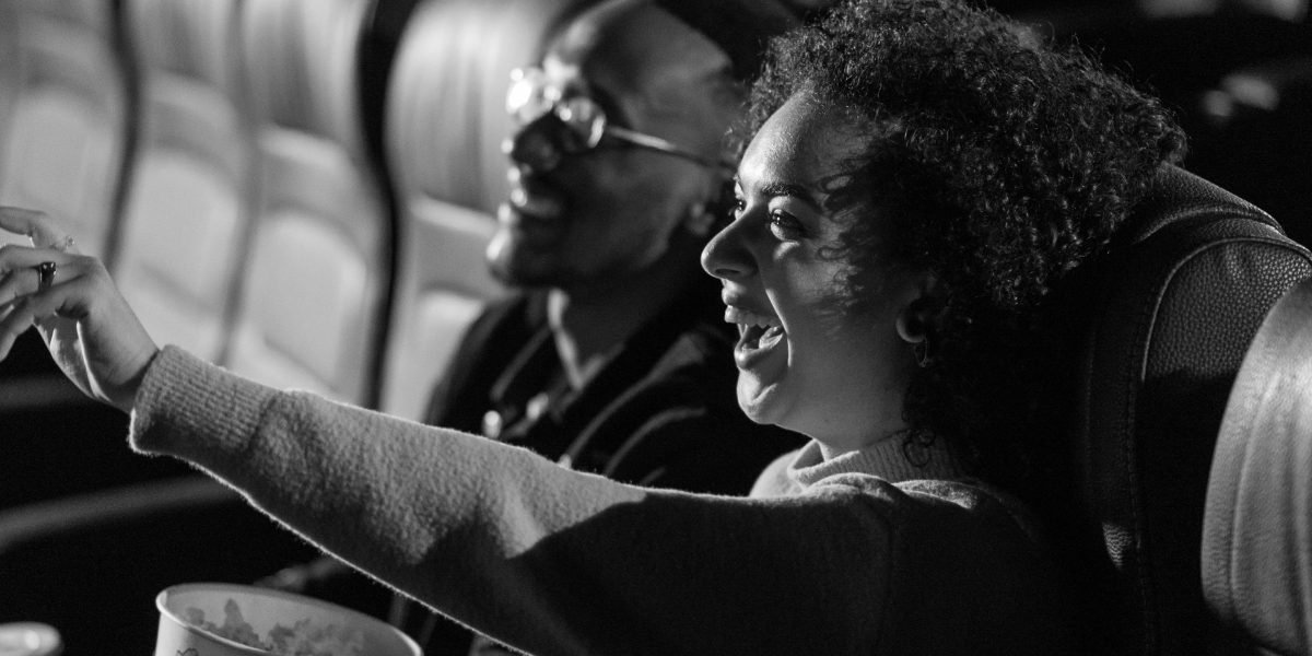 An audience captivated by a comedian's performance, highlighting the impact of visual gags and physical comedy in live entertainment.