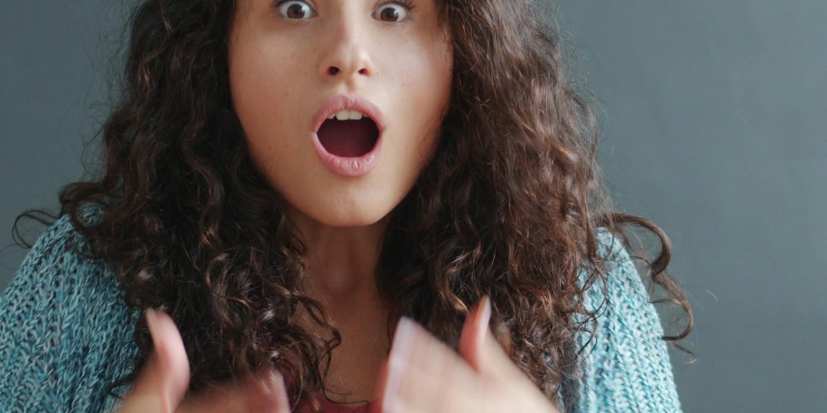 A person reacting with surprise and a giggle, demonstrating the instant impact of visual humor.